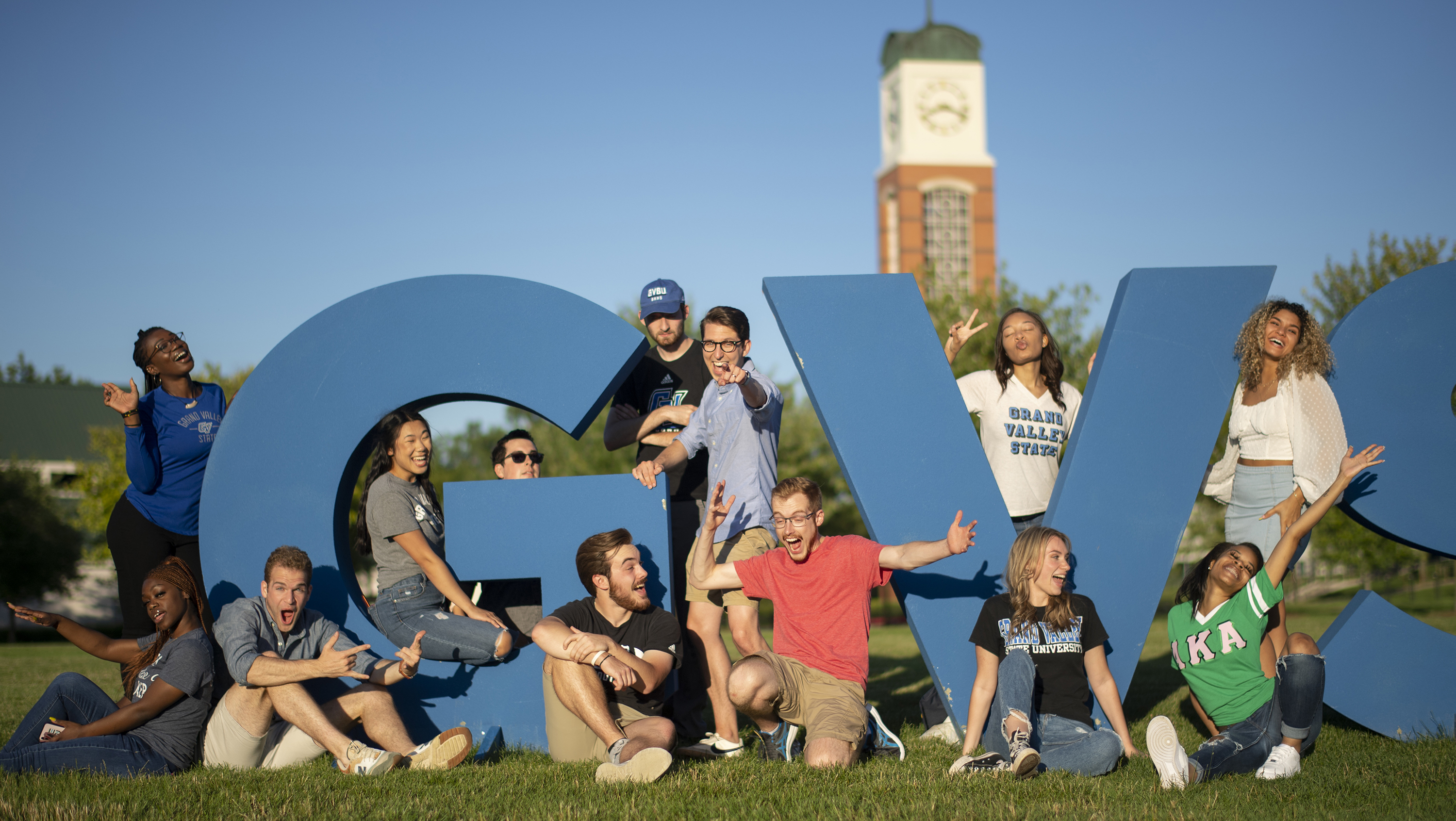 student next to the GVSU letters